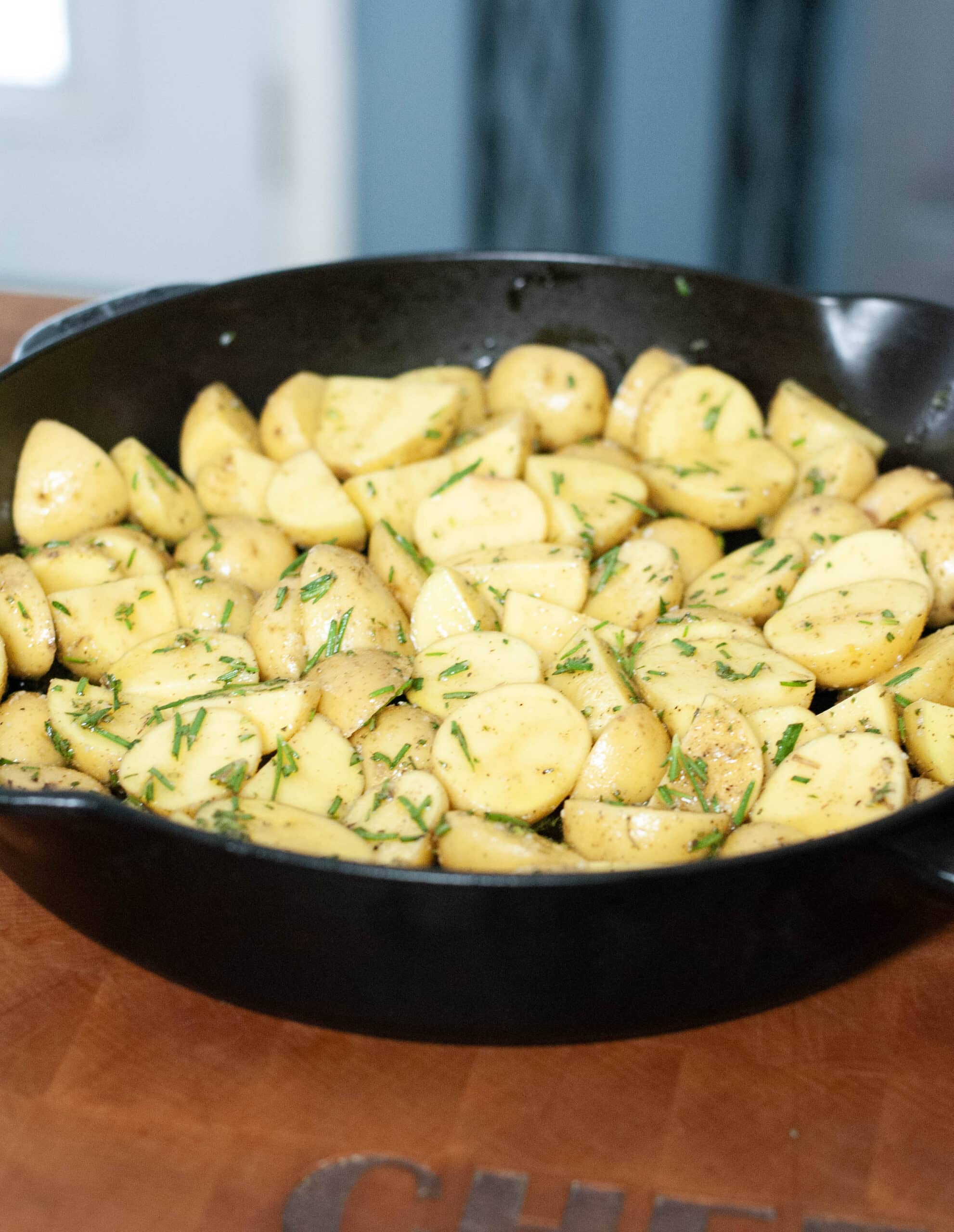 Seasoned potatoes with rosemary in a skillet.