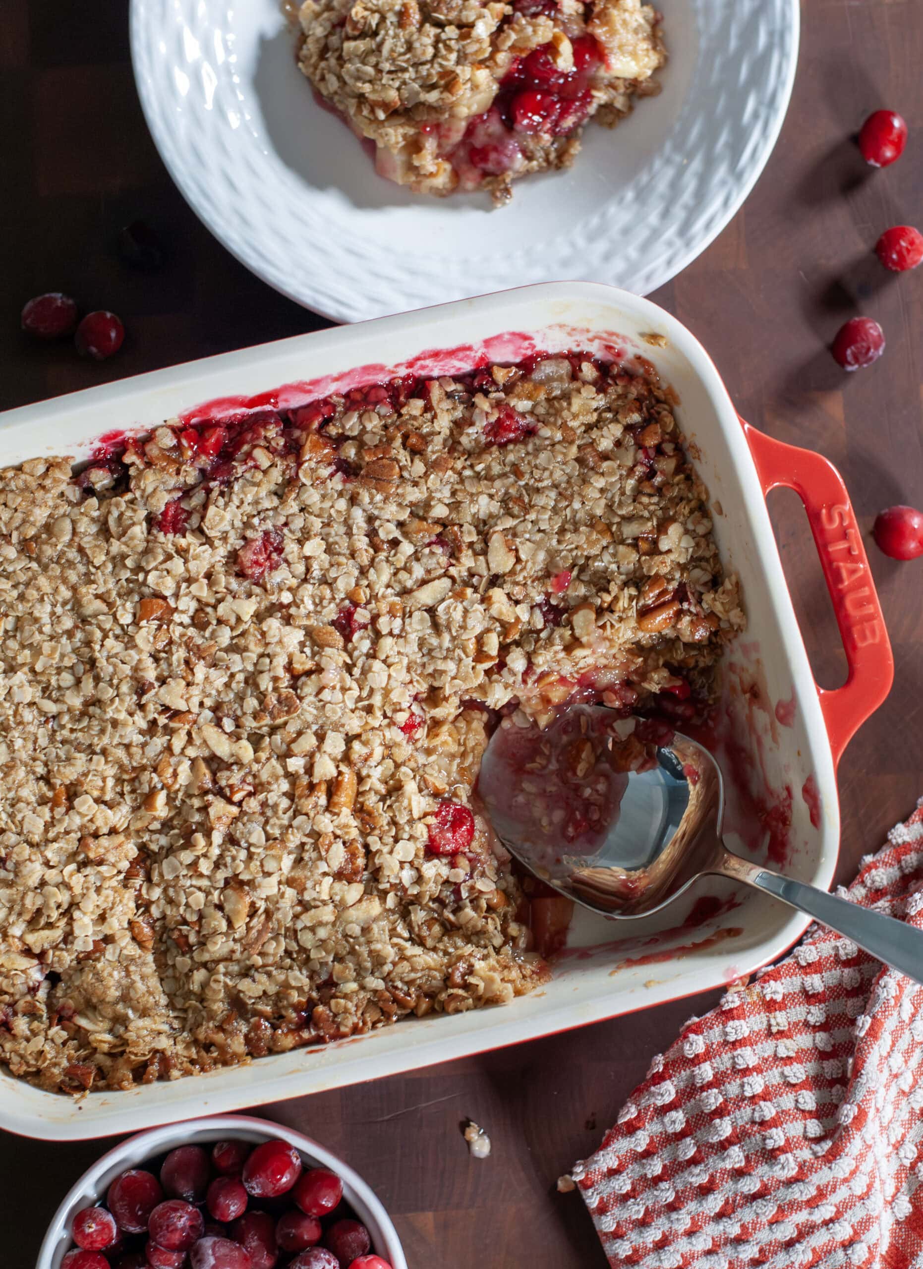 Cranberry Crisp in a red baking dish next to bright cranberries.