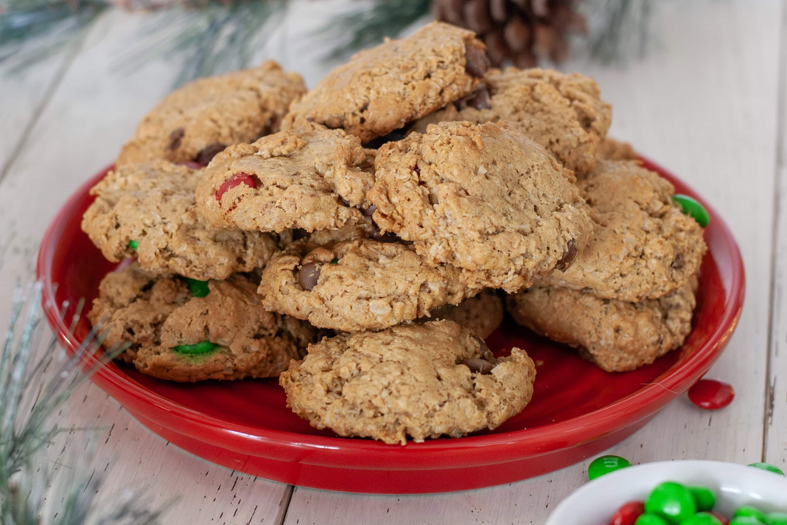 Monster cookies filled with chocolate chips and m&ms on a red plate.