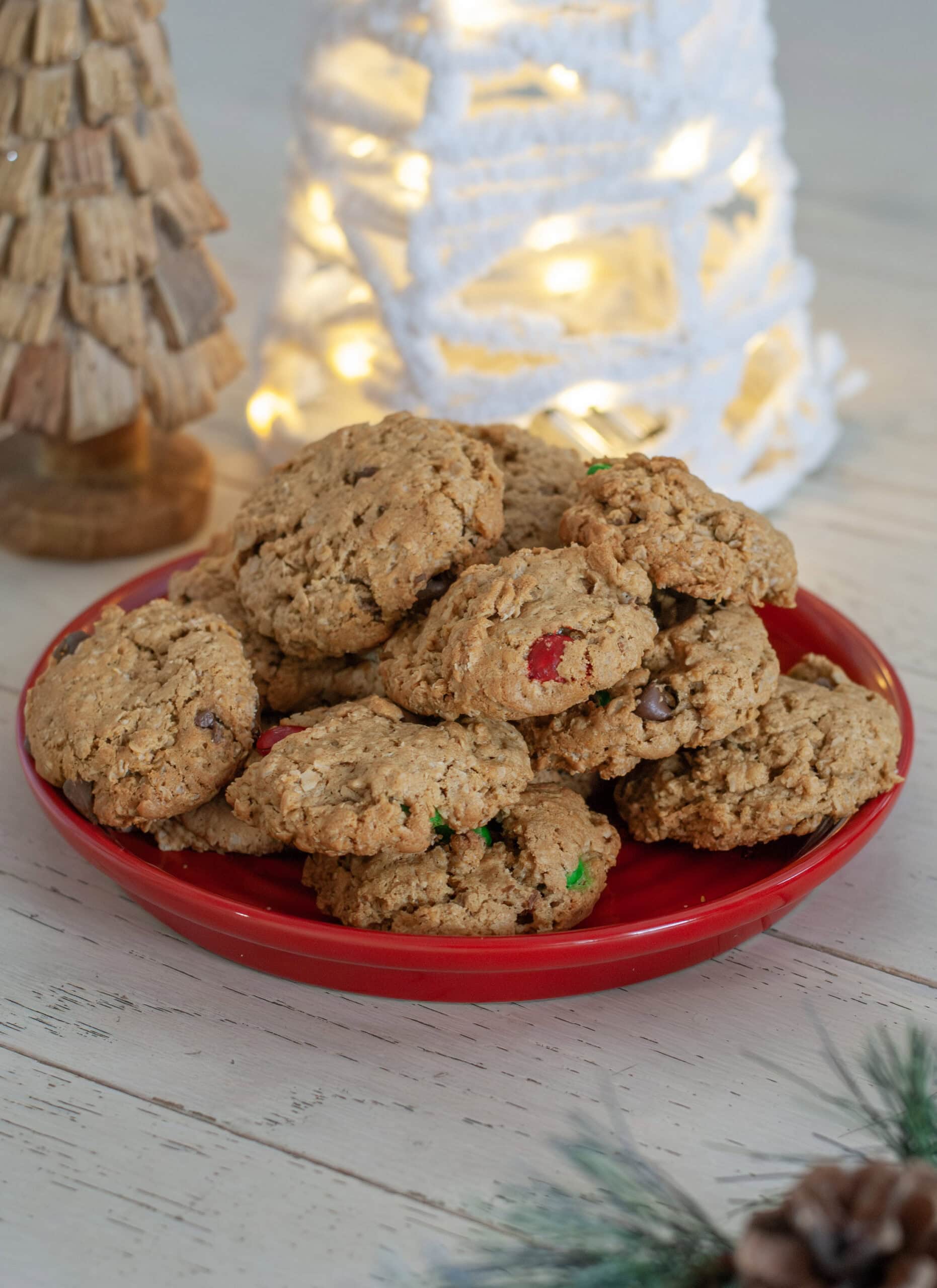 Cookies with M&Ms piled up on a red plate.