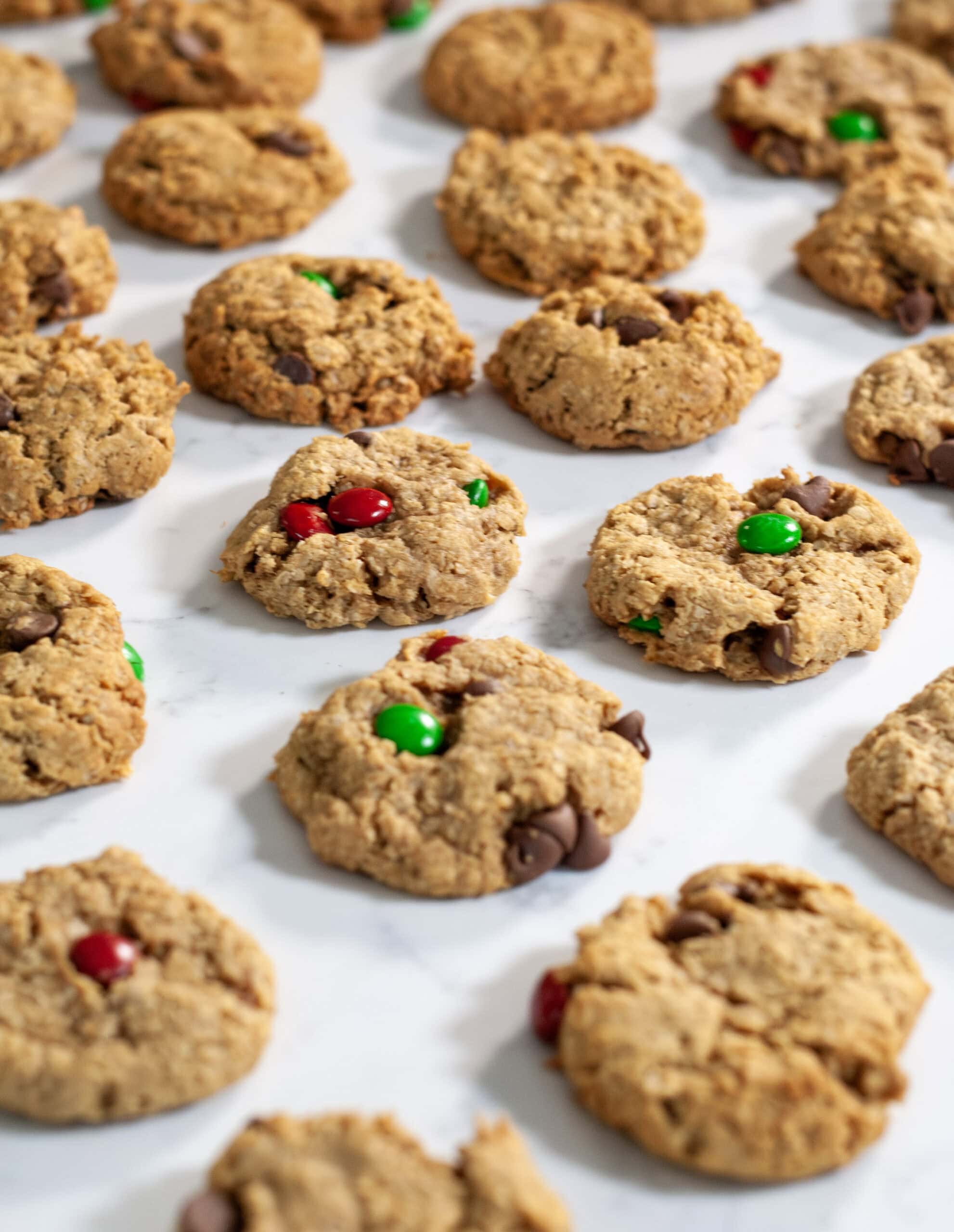 A bunch of monster cookies laid out on parchment paper.