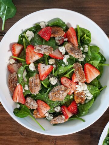 Strawberry salad with pecans and poppyseed dressing with spinach.