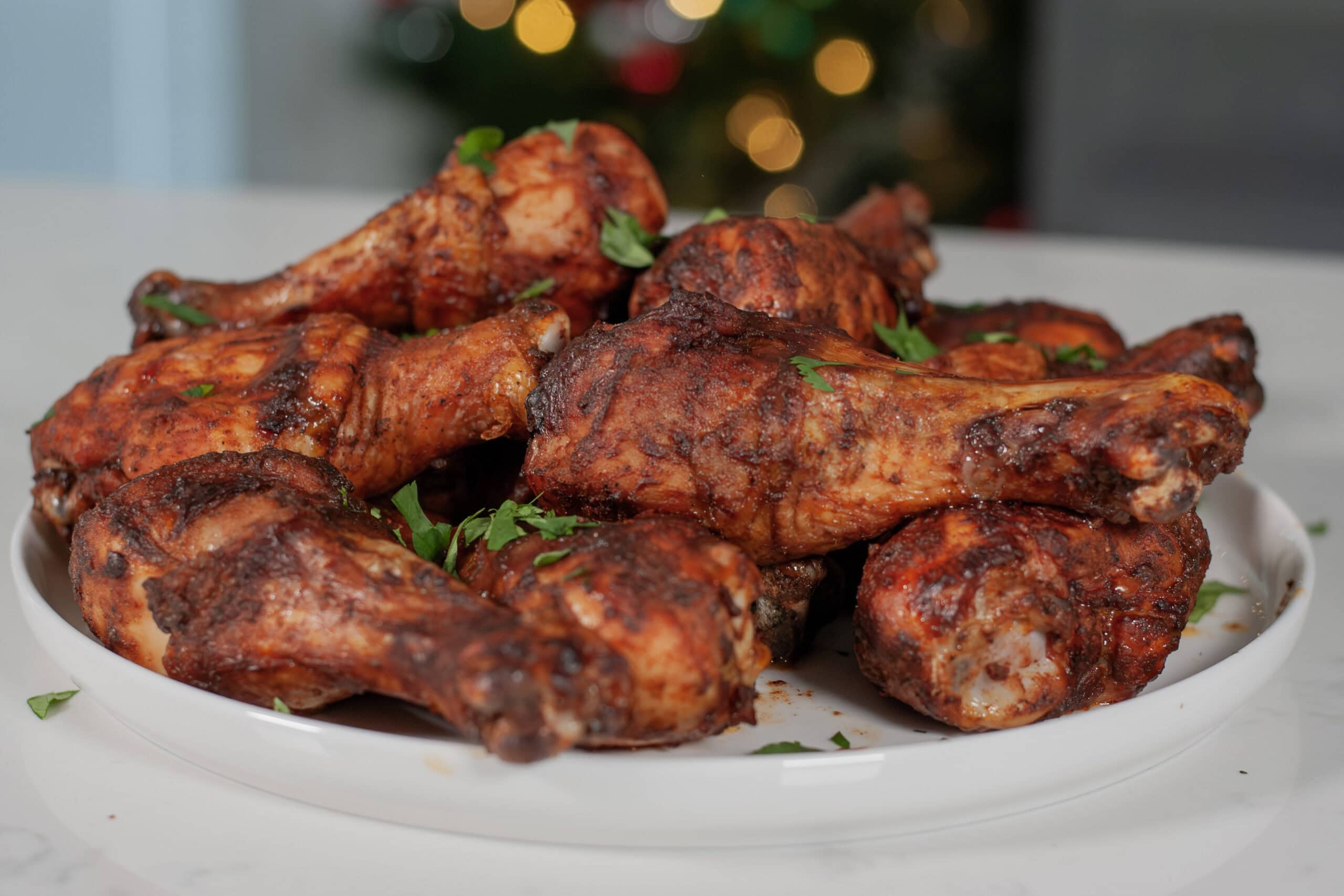 BBQ covered chicken legs topped with parsley.