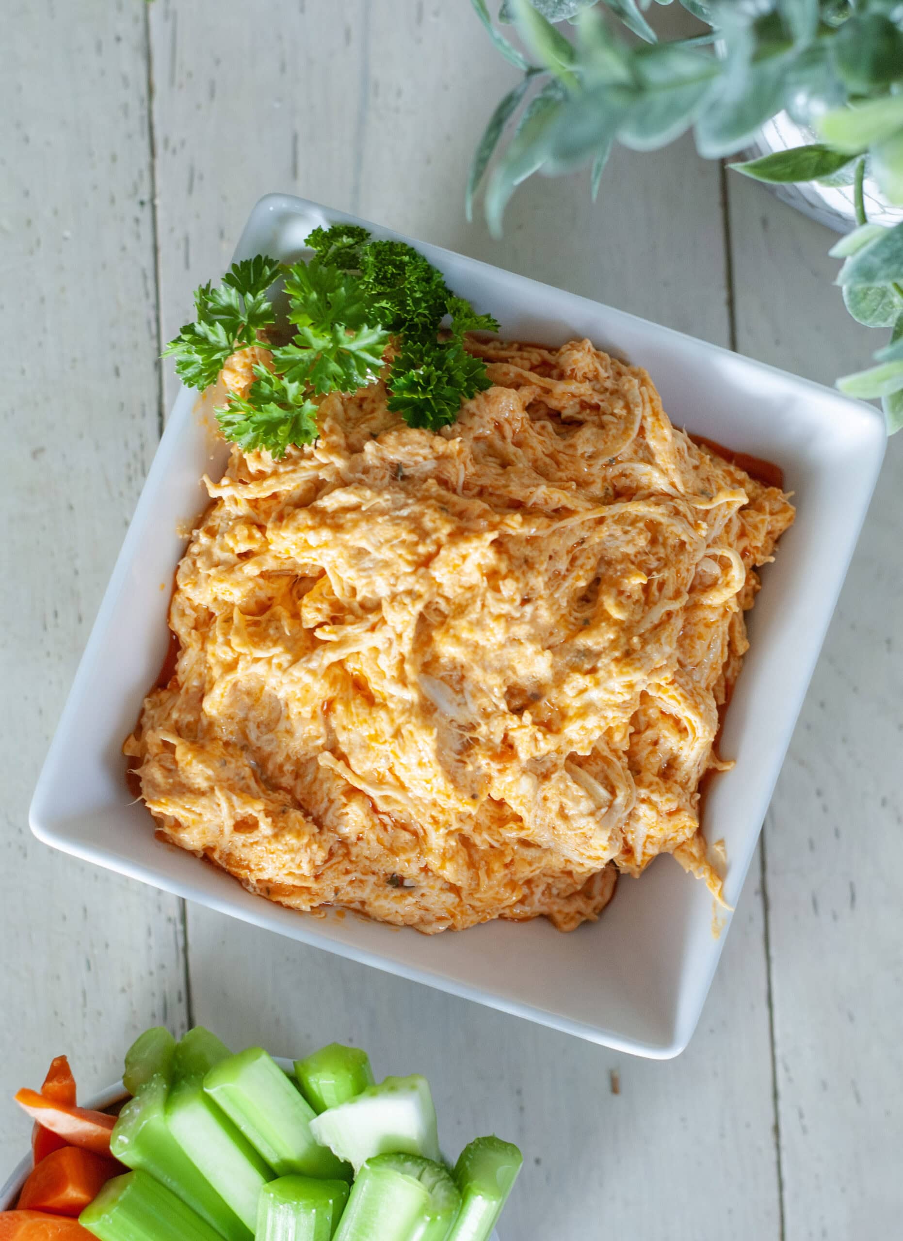 Buffalo Chicken Dip in bowl with carrots and celery.