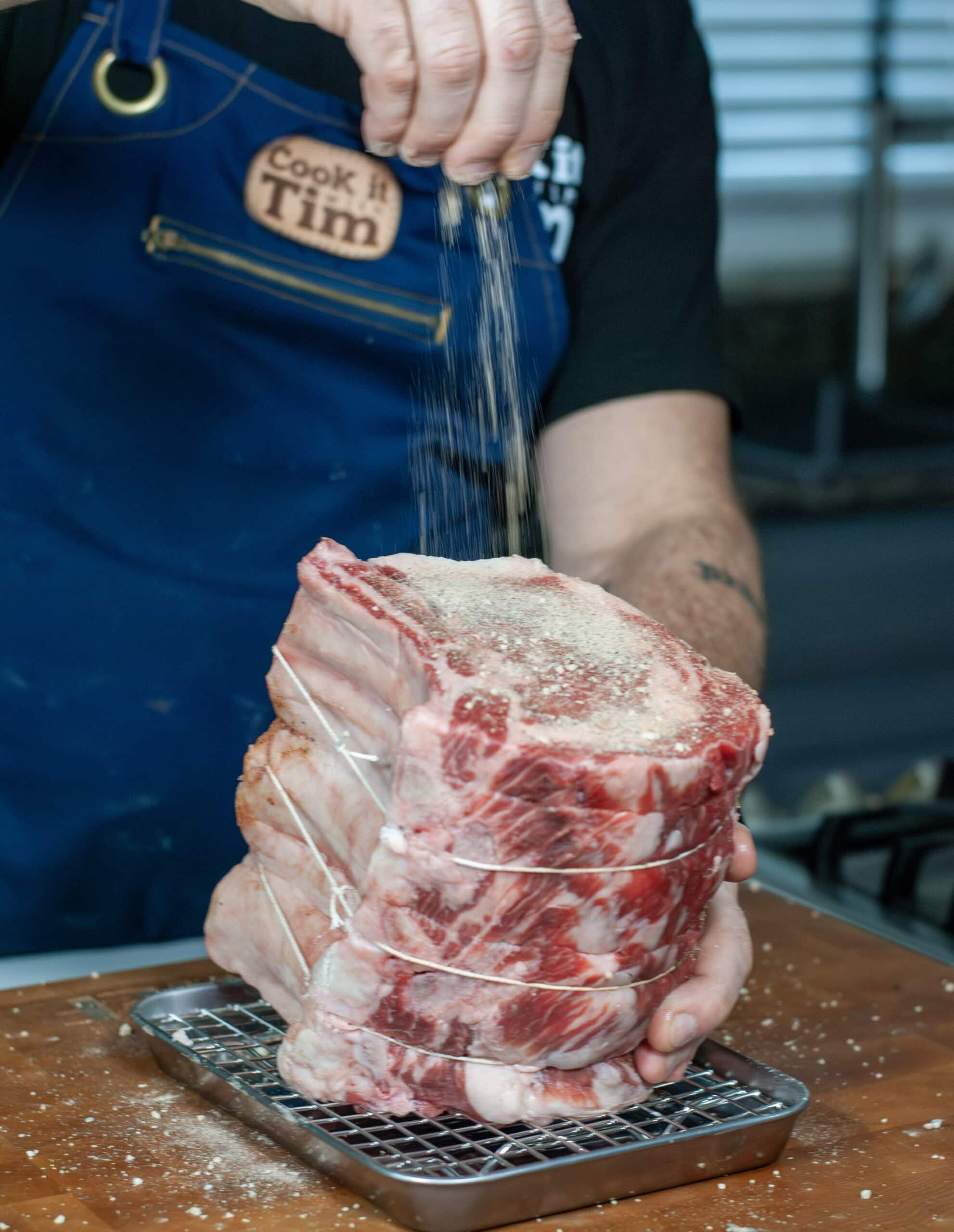 Ribeye Roast being seasoned with prime rib seasoning.