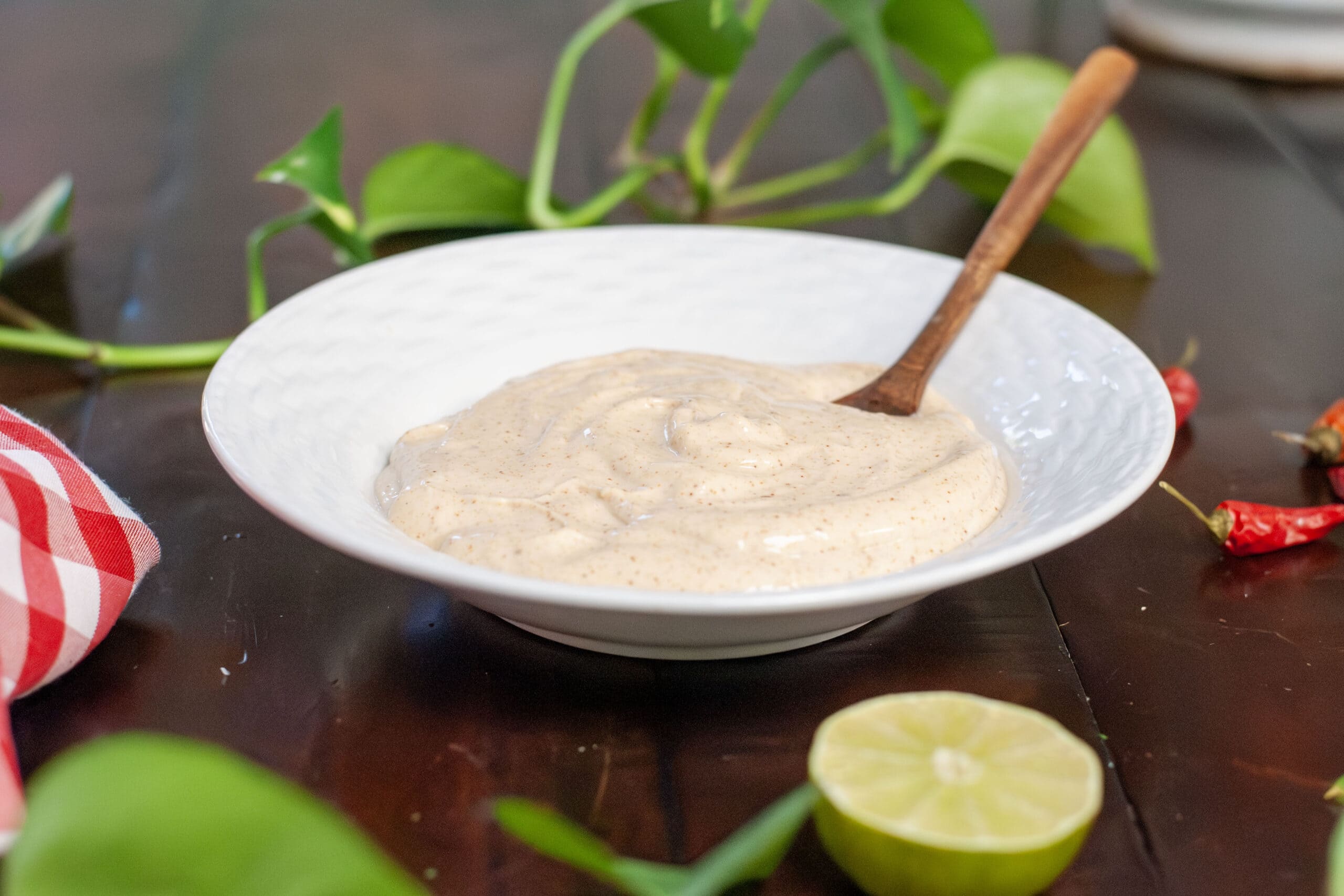 Dip in a white bowl with limes and peppers.