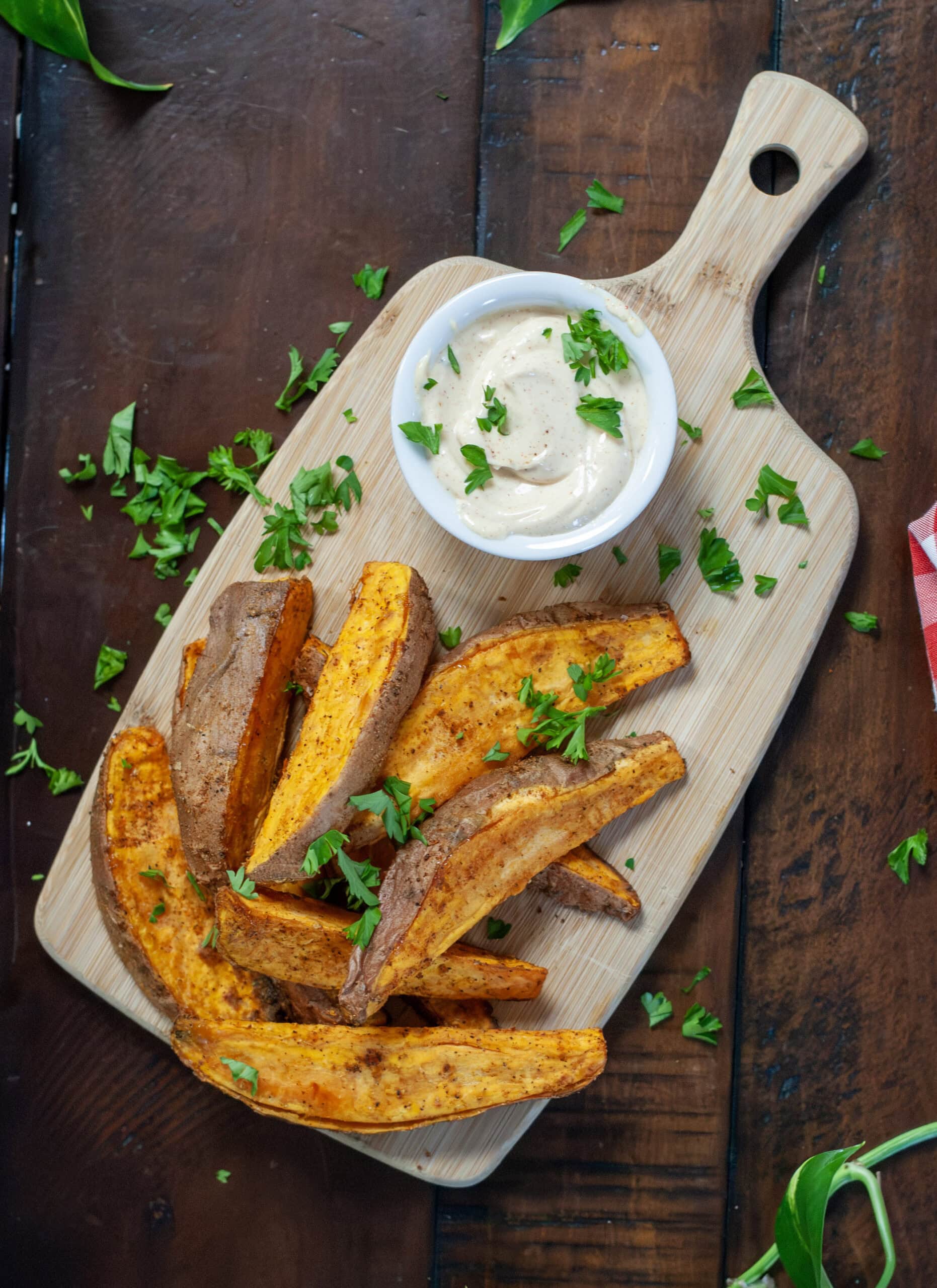 Sweet Potato fries on the board next to red napkin.