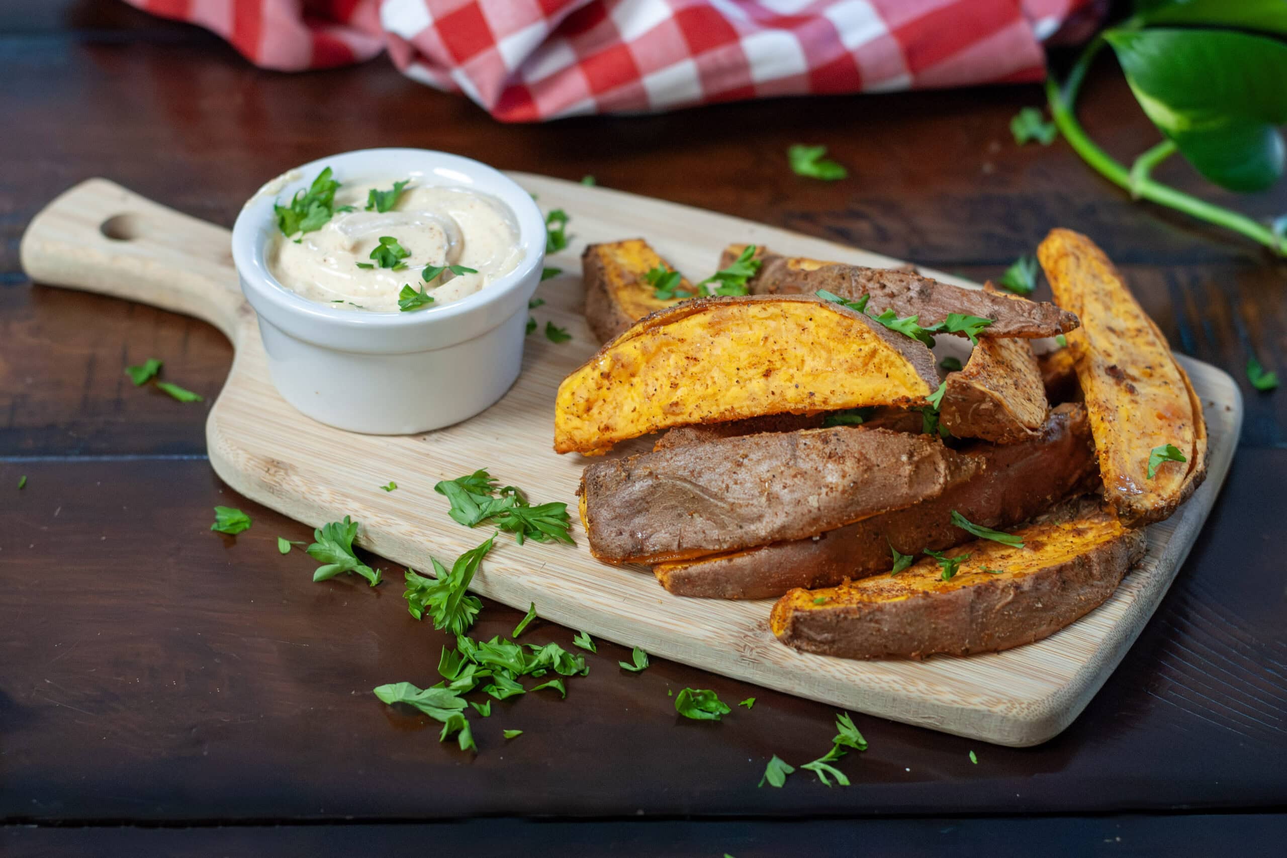 Sweet Potato wedges on a board with parsley and a southwest dip.