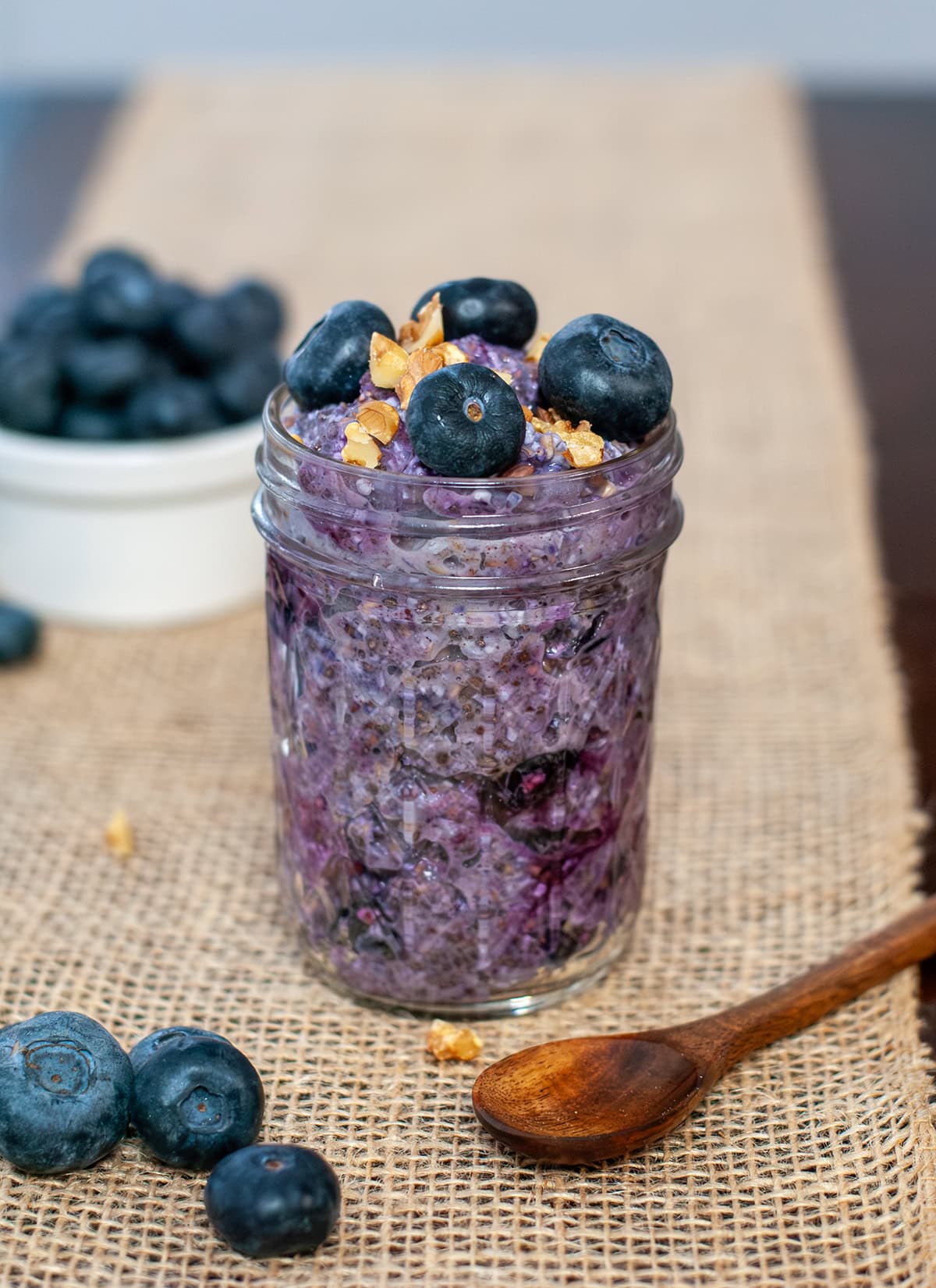 Blueberry overnight oats in a jar next to blueberries.