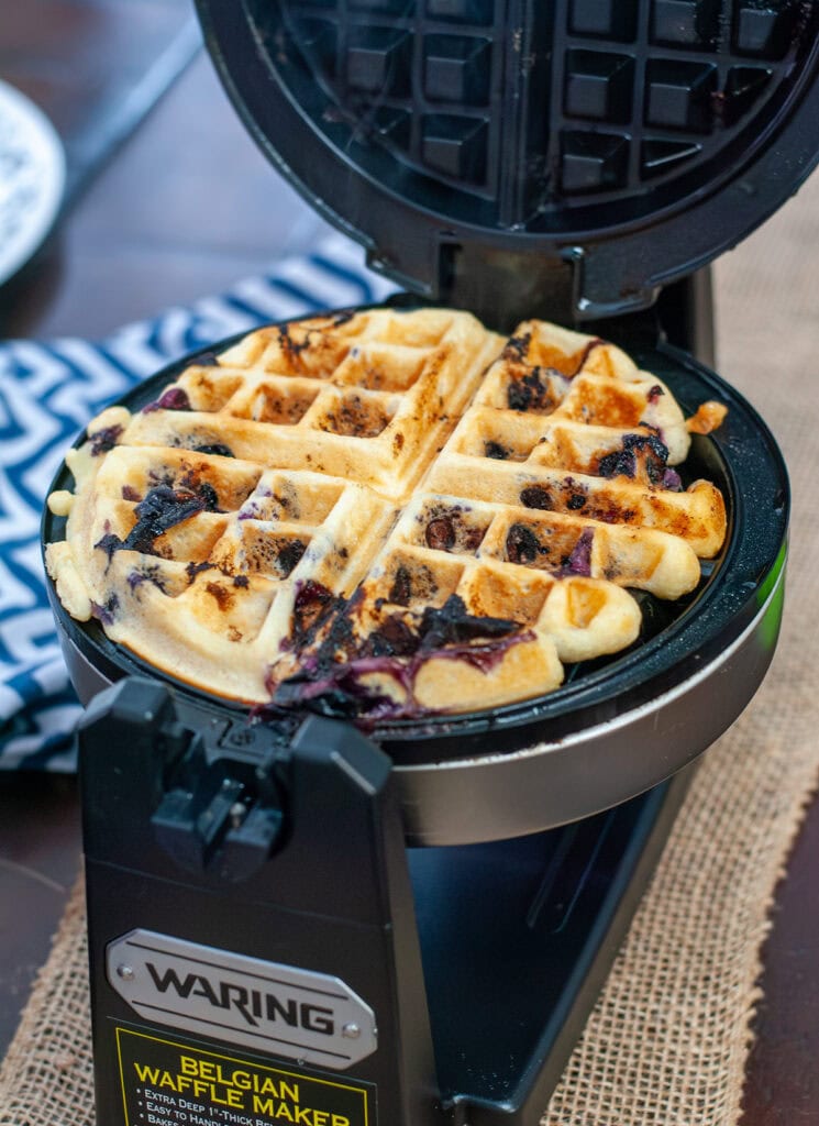 A blueberry waffle in belgian waffle maker.