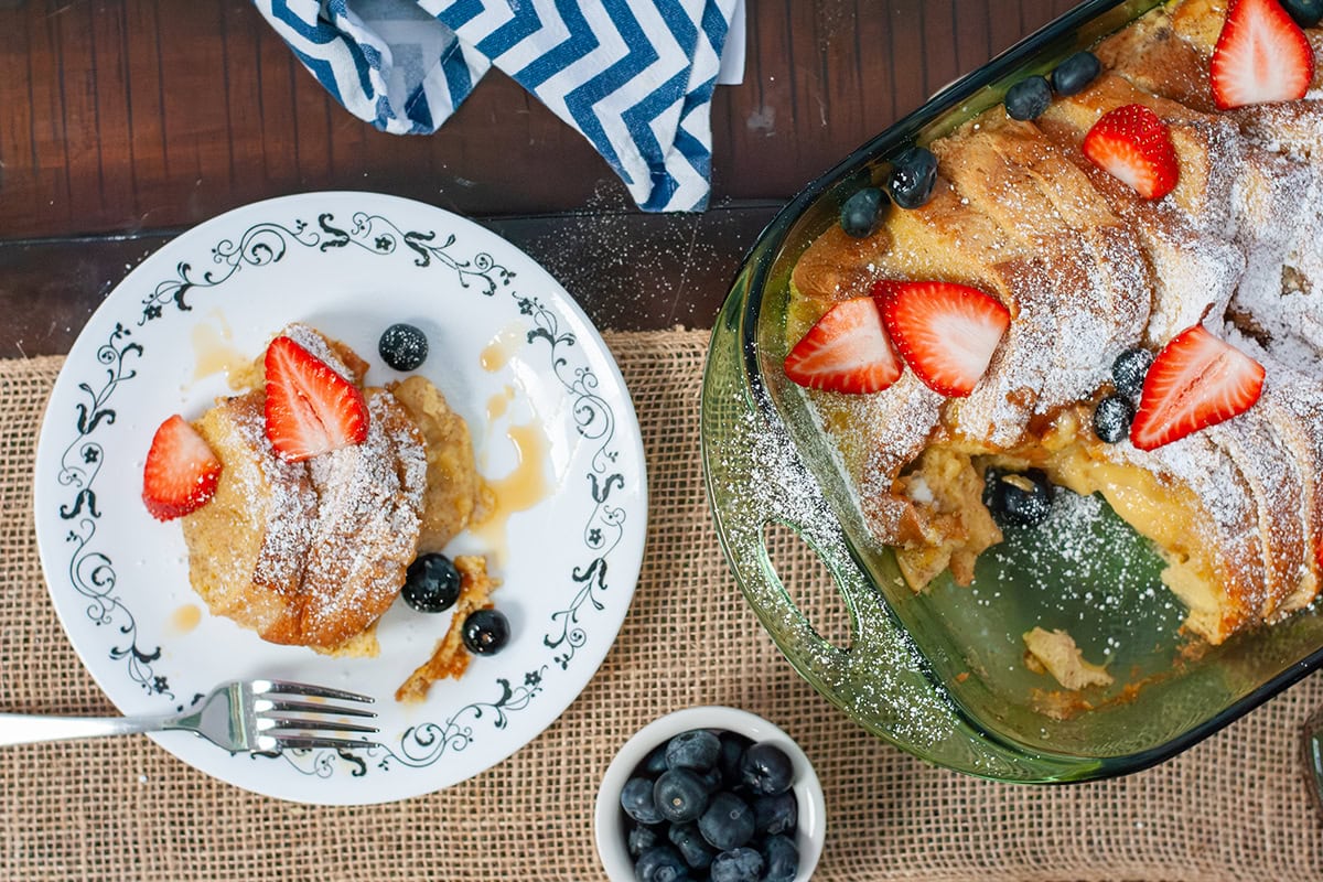 Brioche toast on a plate with blueberries and strawberries.