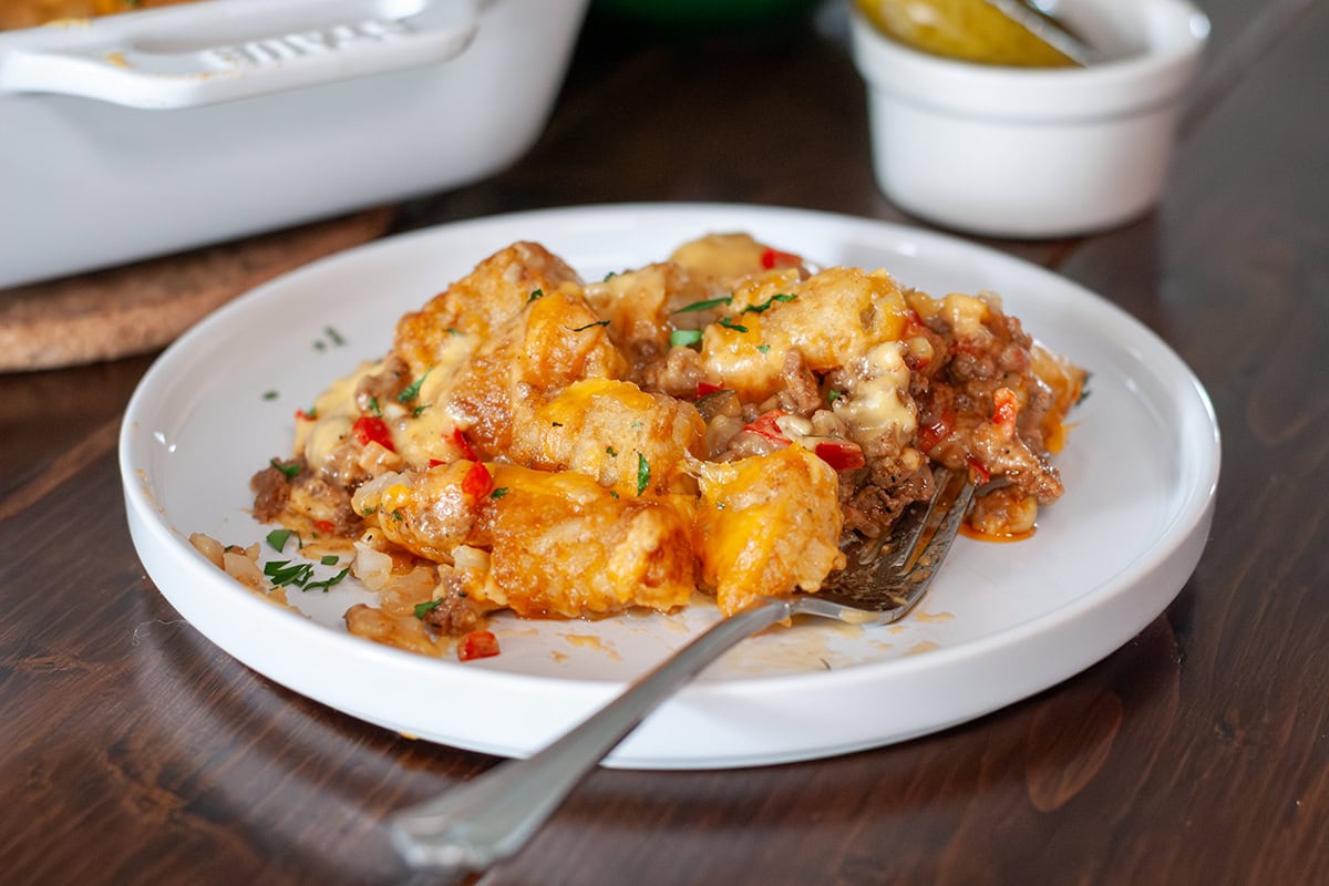 A plate of cheeseburger tater tot casserole topped with chives.