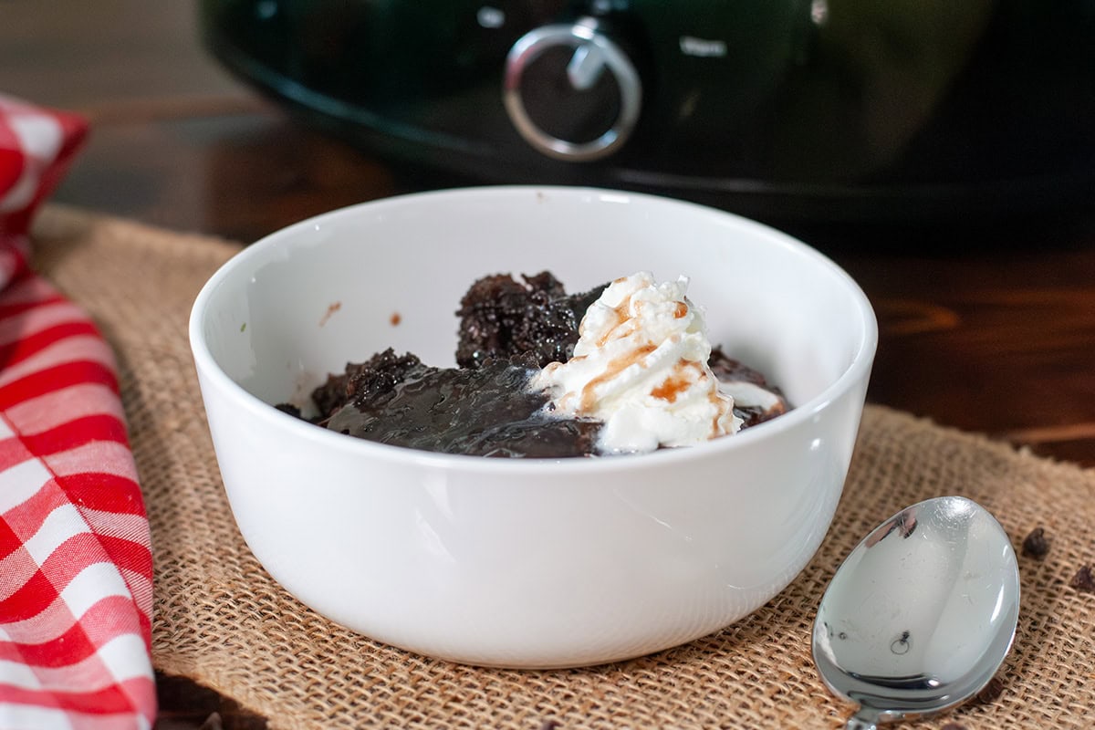 A bowl of chocolate lava cake next to a crock pot.