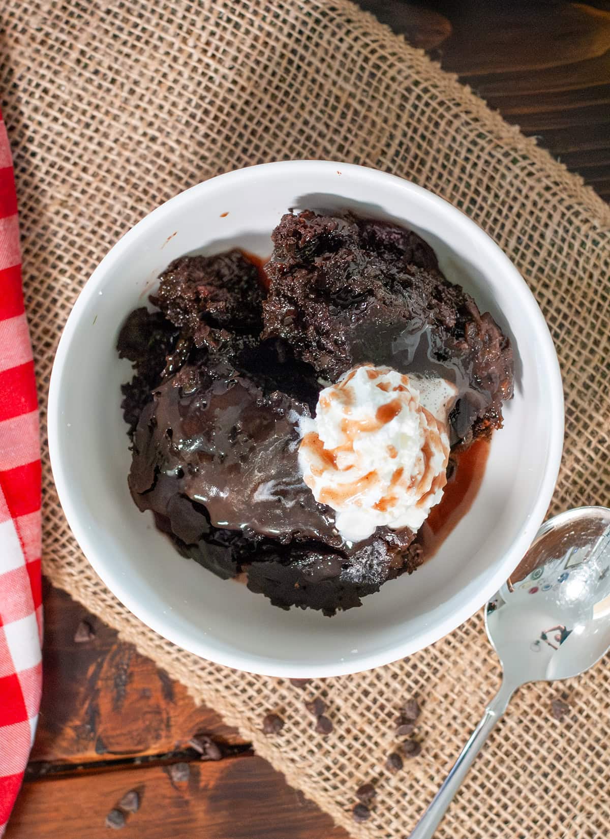 Chocolate lava cake in a bowl with whipped cream and mini chocolates.