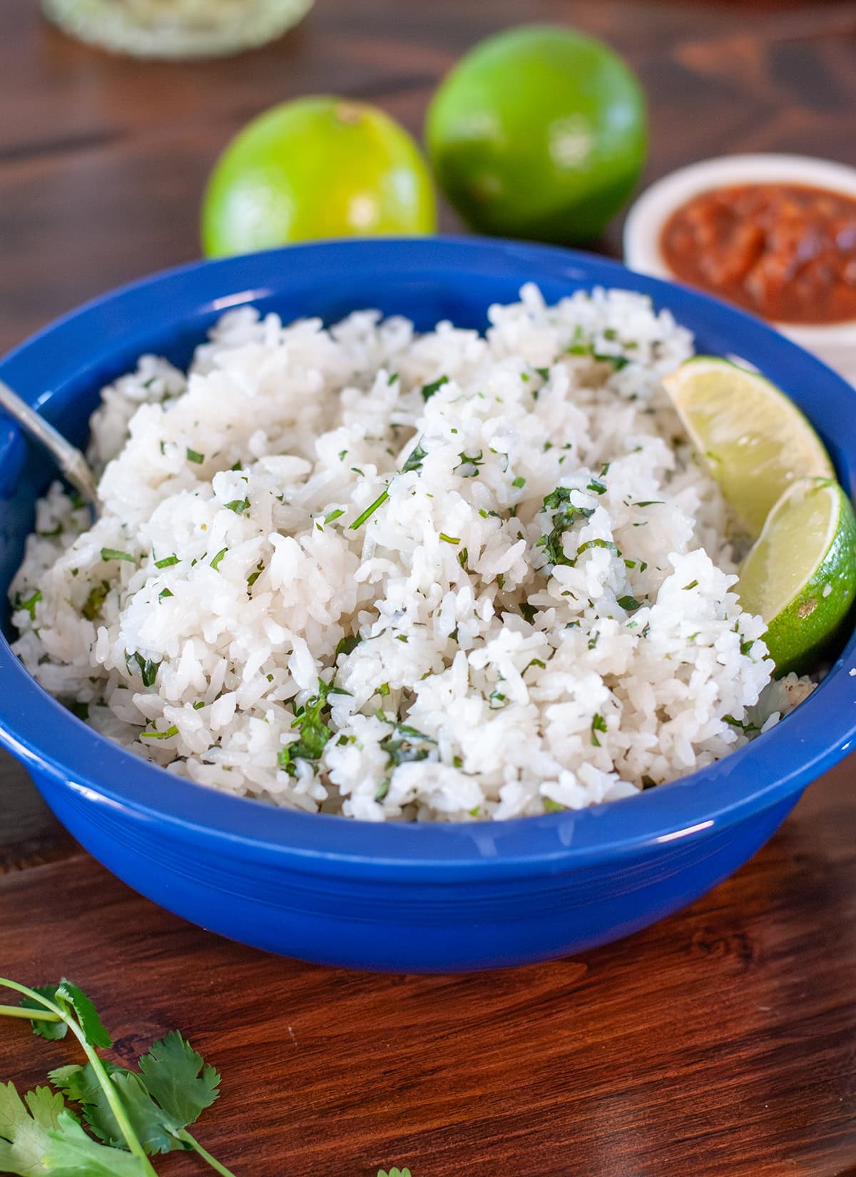 A bowl of cilantro lime rice with lime slices.