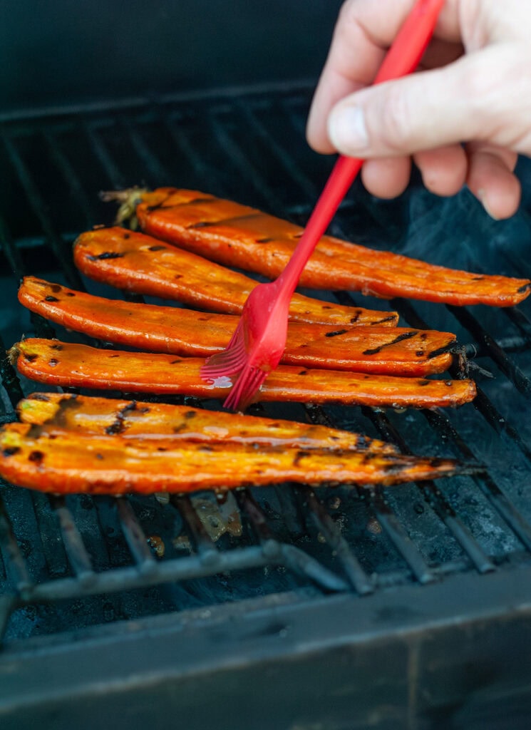 Glaze brushing over grilled carrots.