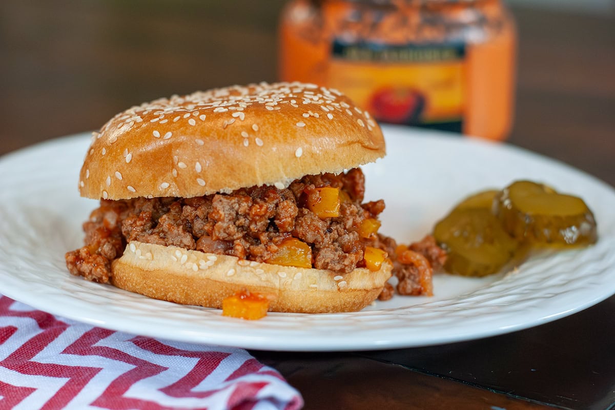 Turkey sloppy Joe on a plate with pickles.