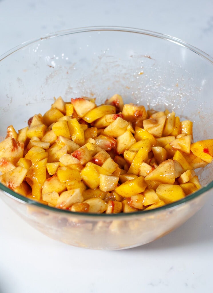 Seasoned peaches and mangos in a bowl.