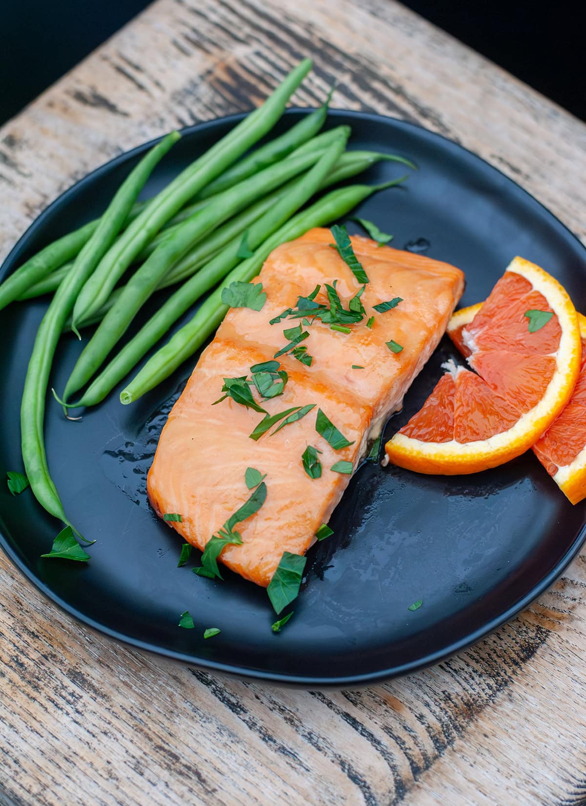 Salmon on a plate topped with parsley.