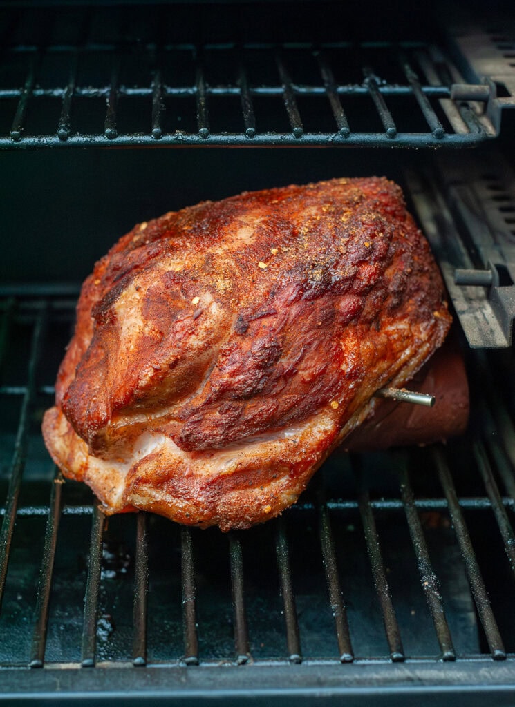 A bone-in ham on a smoker.