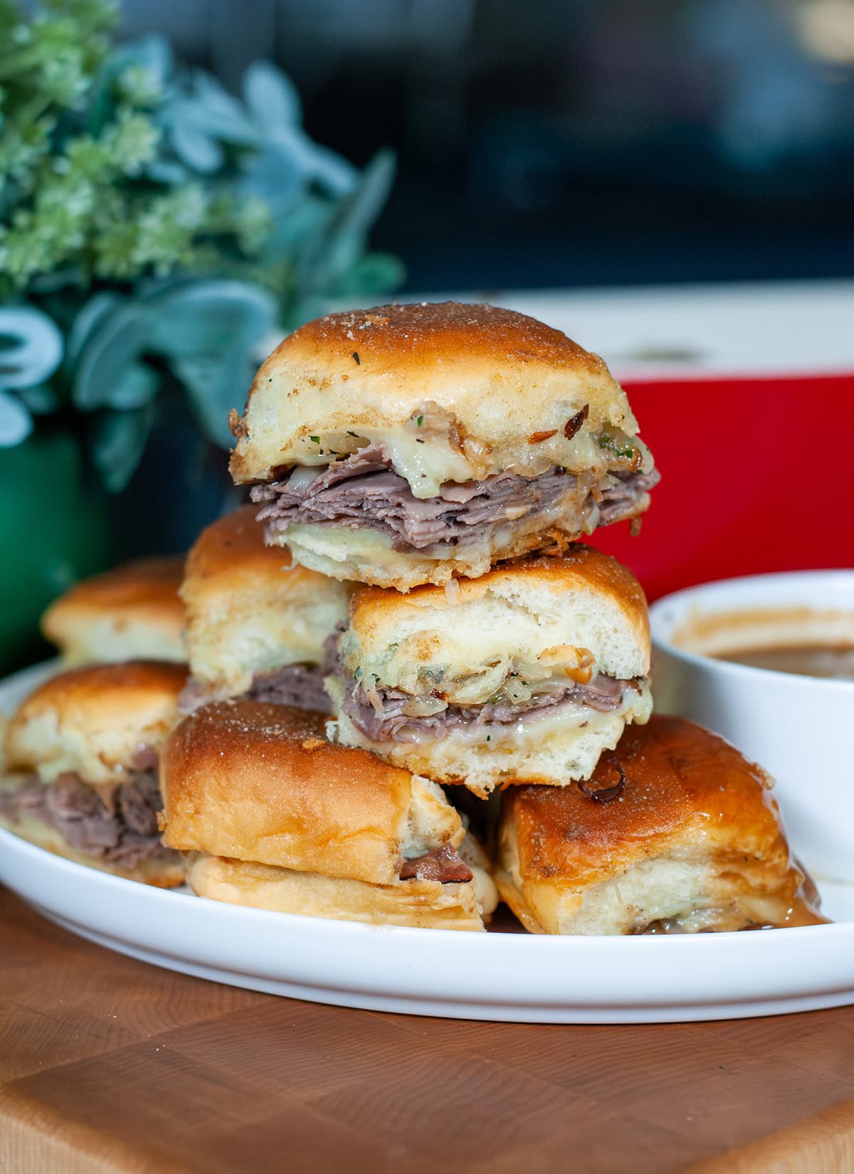 A stack of slider sandwiches showing layered beef and melty cheese. 