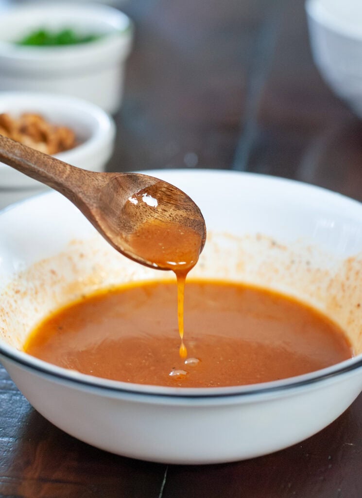 A spoon full of sauce for sweet potato salad.