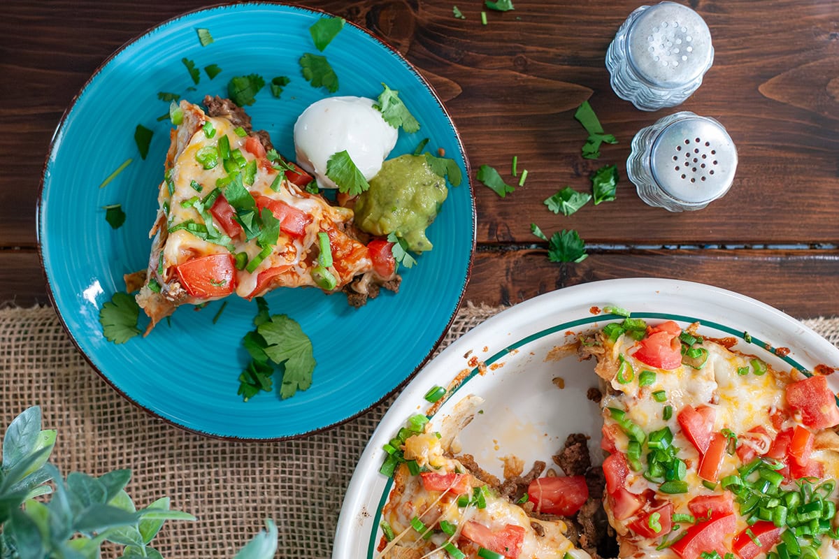 A slice of taco pie served with sour cream.