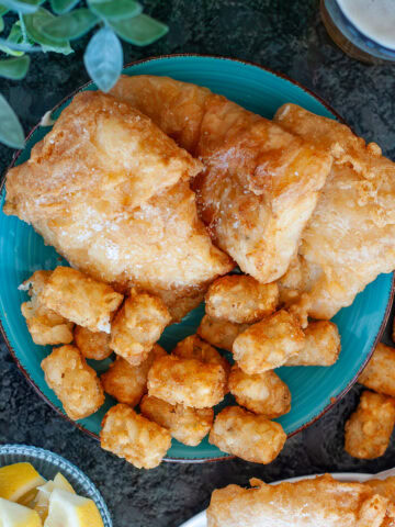 Beer battered fish with tater tots and lemons.