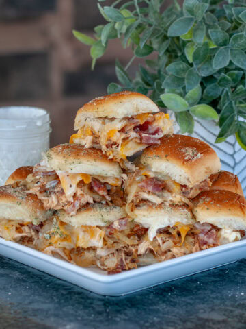 Chicken bacon ranch sliders piled up on a plate.