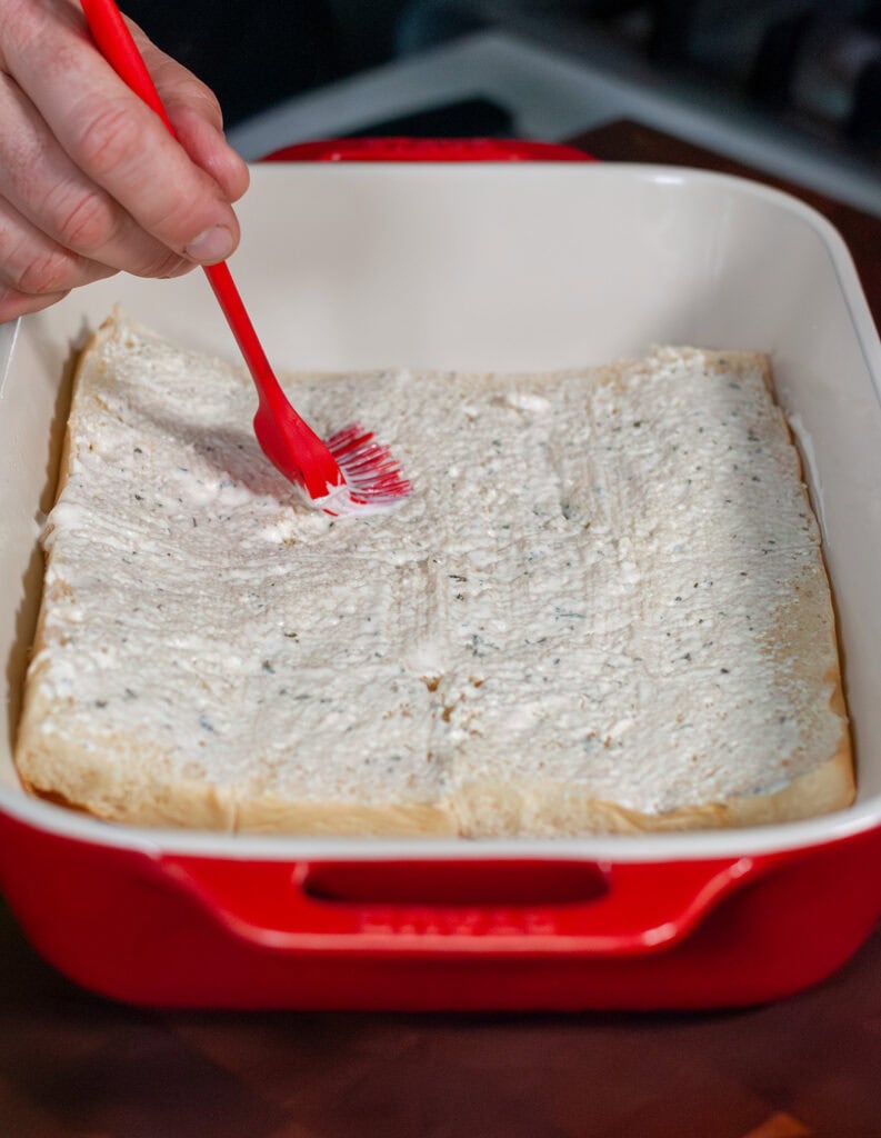 Ranch being brushed onto buns.