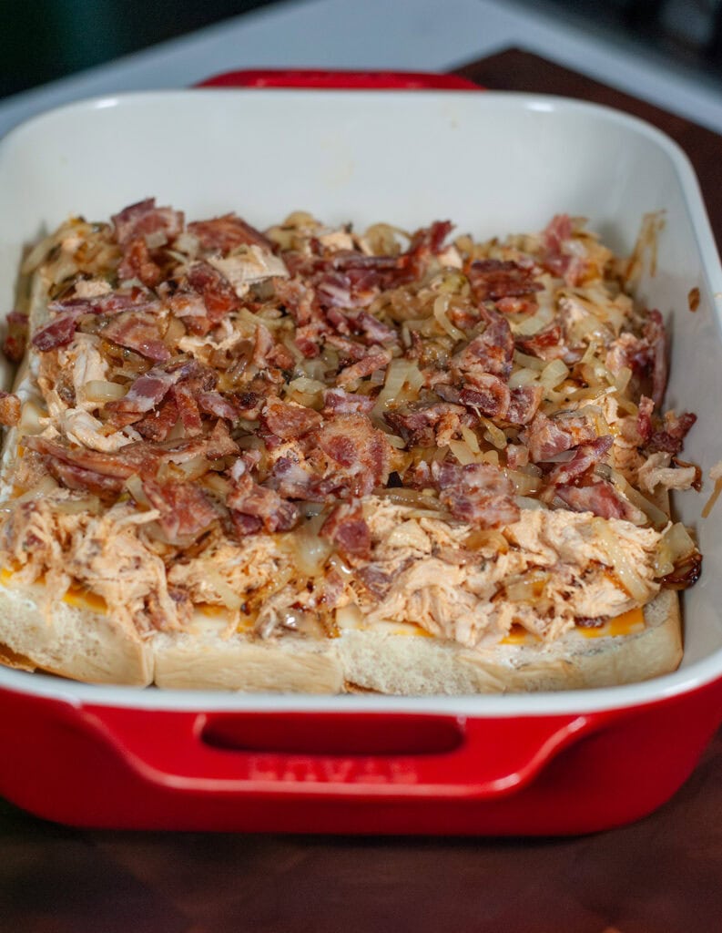 A layer of chicken and bacon on a slider bun.