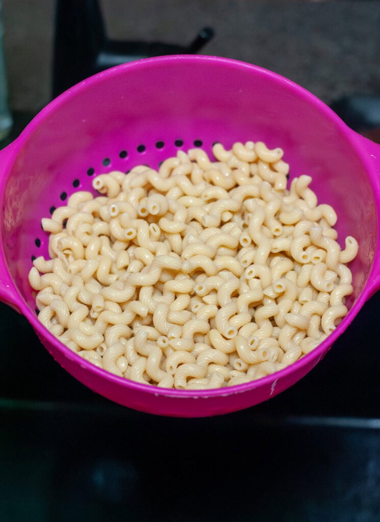Macaroni noodles in a strainer.