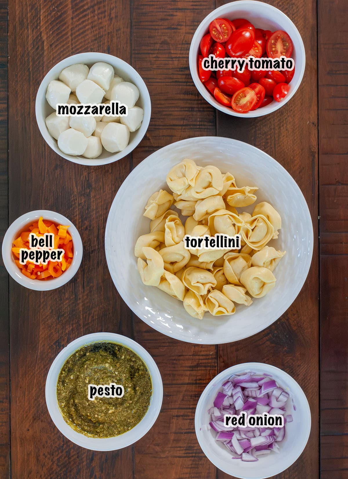 Labeled ingredients needed to make pesto pasta salad.