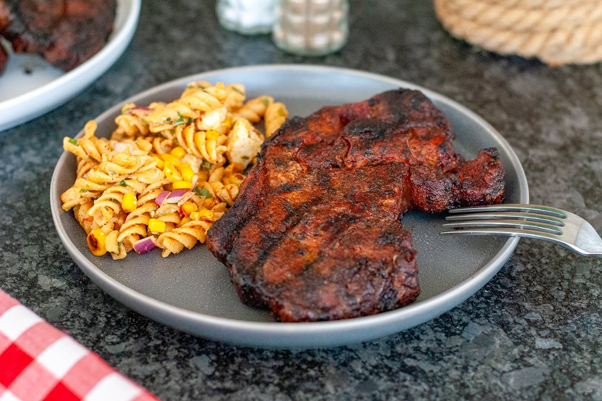 Pork Steak on a plate with pasta salad.