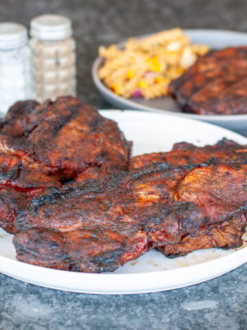 Pork Steaks on a plate with pasta salad.