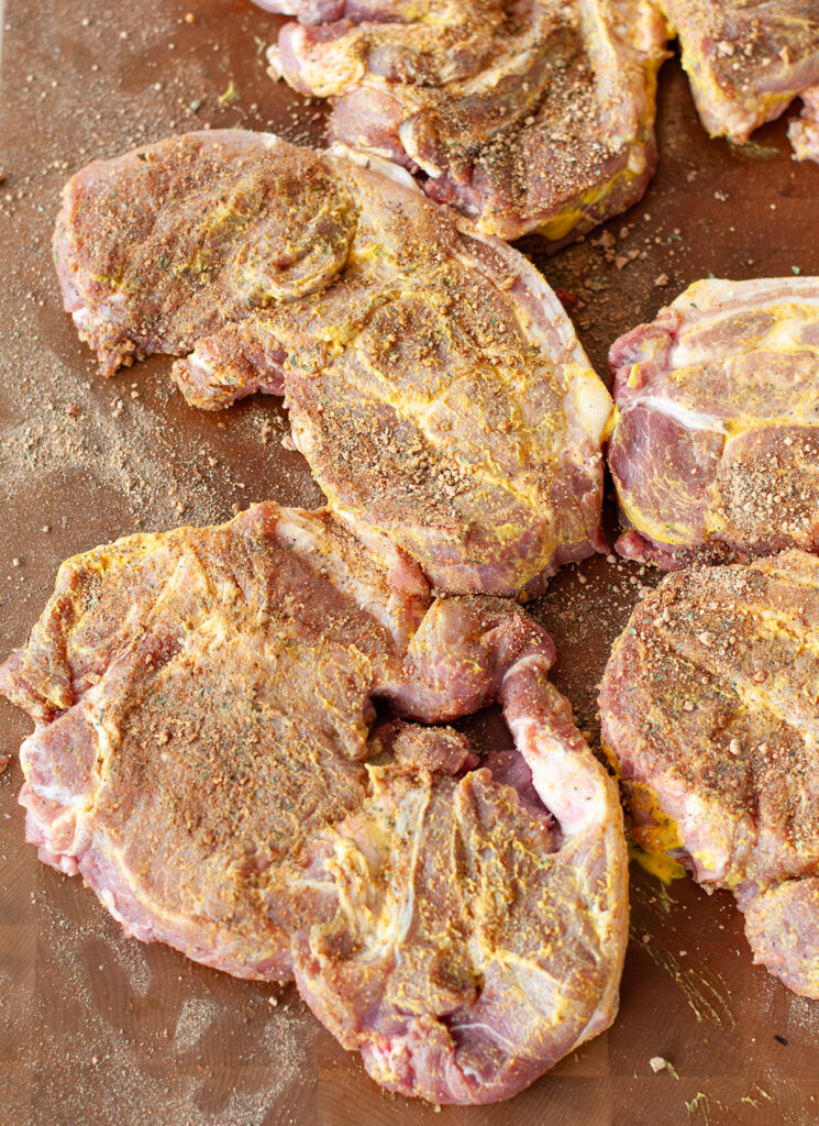 A top view of freshly seasoned pork steaks. 