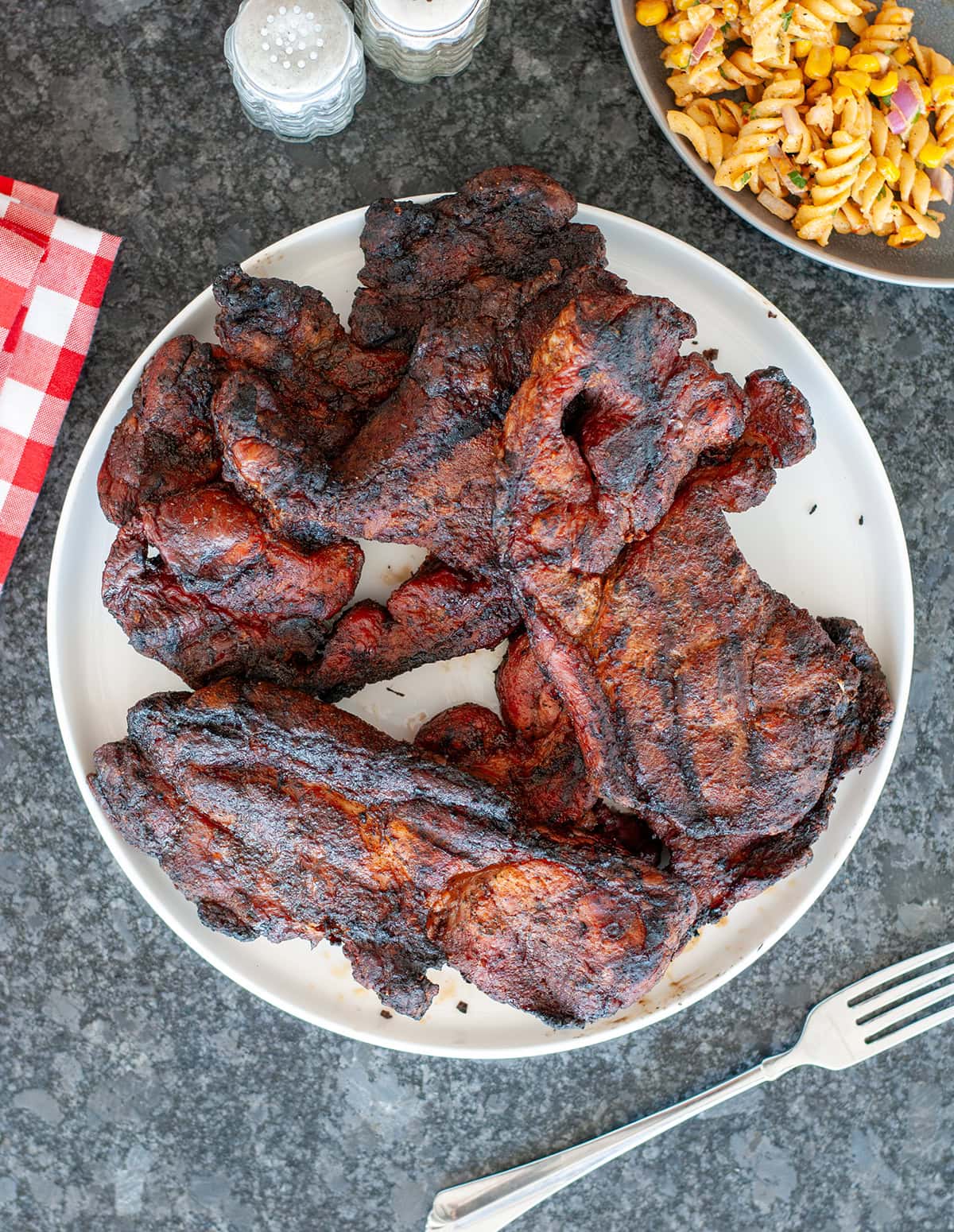 A top view of finished pork steaks on a plate. 