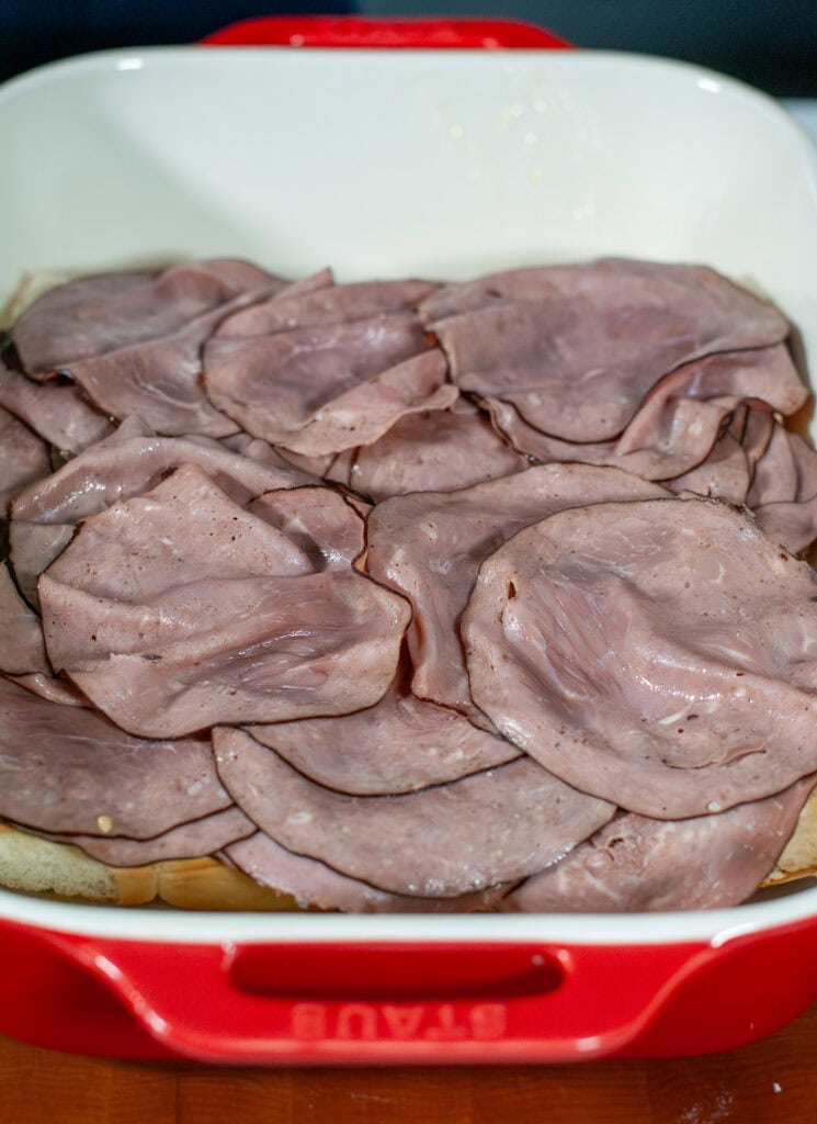 The roast beef slices and layered on the bottom rolls. 