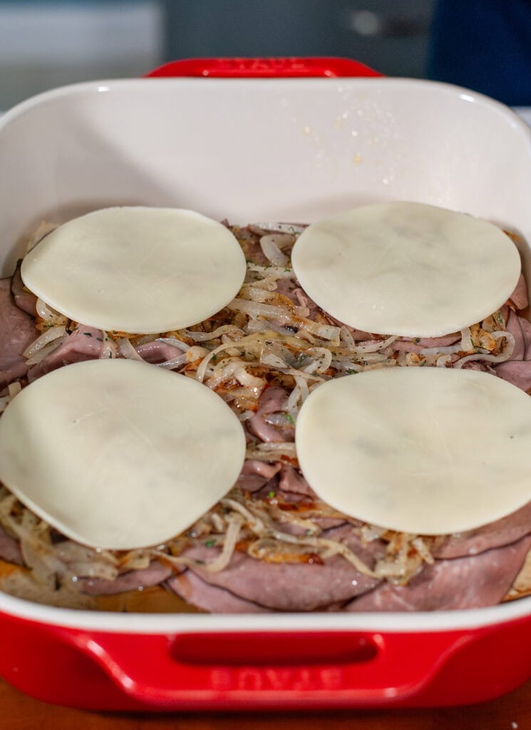 Sliced provolone cheese layer on the onion for the sliders. 