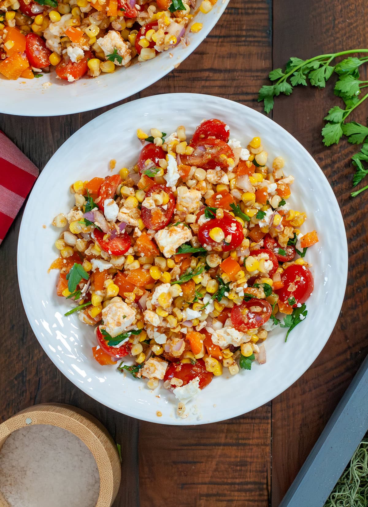 Roasted corn salad in a bowl with dressing and bright vegetables.