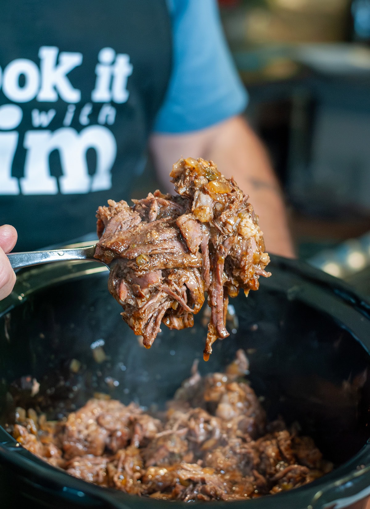 Close up photo of shredded roast on a fork ready to serve. 
