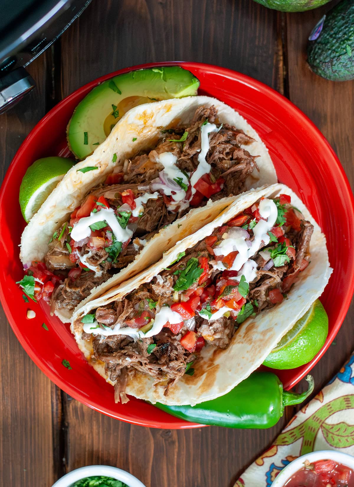 A top view of beef tacos with sour cream and salsa. 