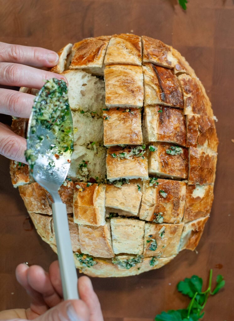 Butter mixture going into crevices of bread loaf.