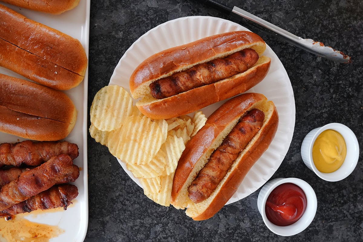 Top view of finished hot dogs with chips, mustard and ketchup.