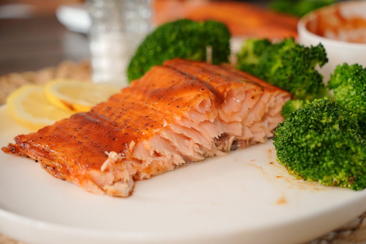 A plate of BBQ salmon with broccoli.