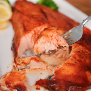 A forked bite of finished flakey salmon.