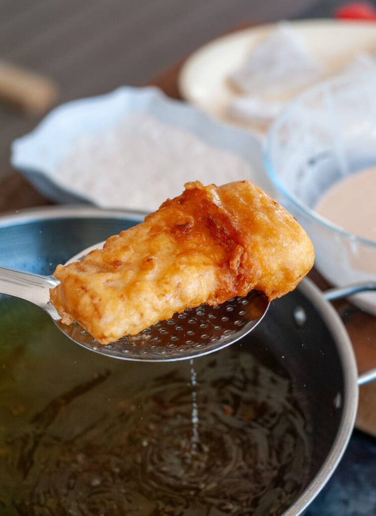 Fried fish straining over oil.