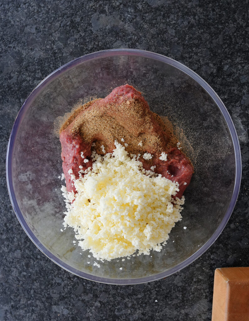 The grated butter, seasoning mixture and ground beef ready to be mixed. 