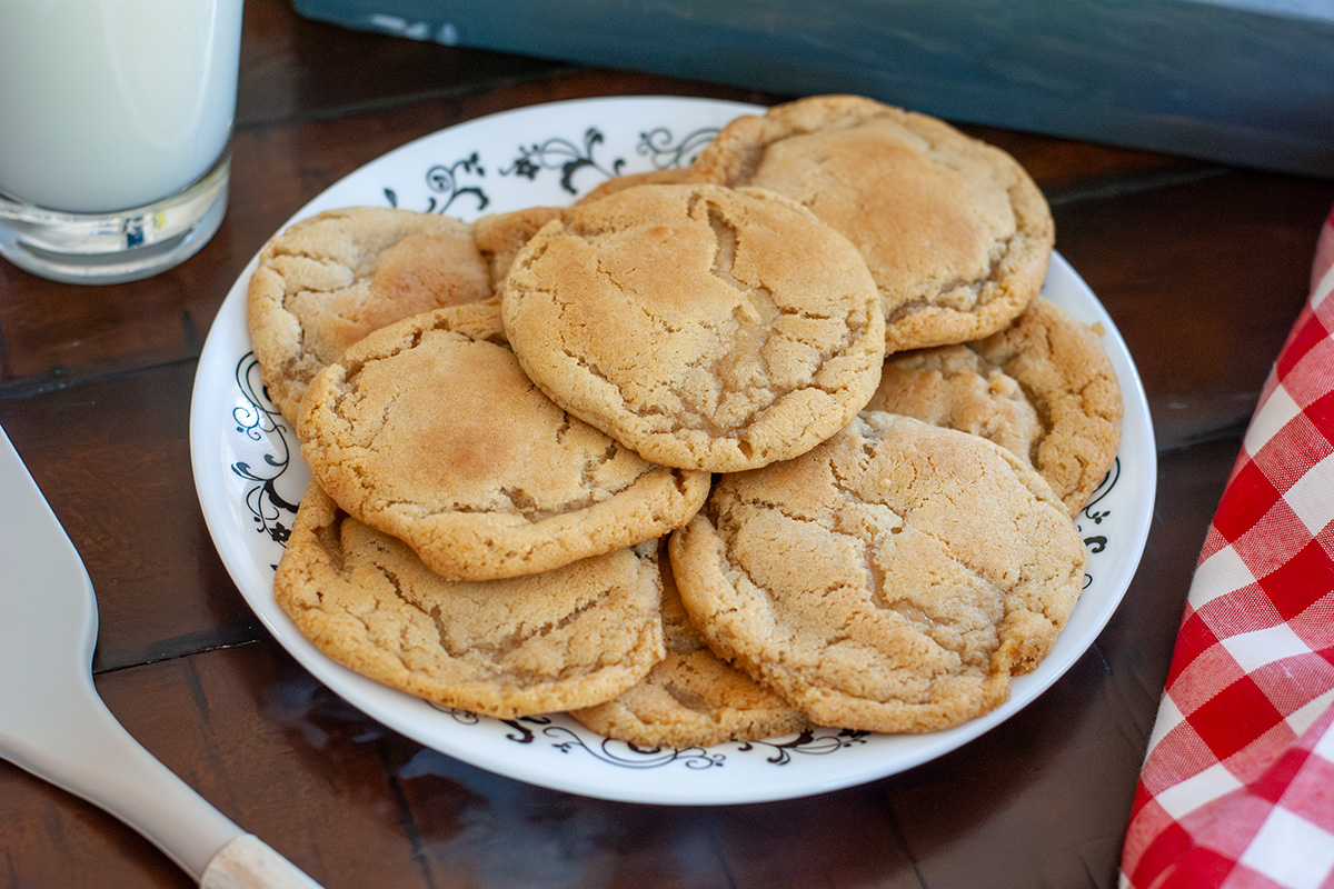 A plate of chipless cookies with a glass of milk. 