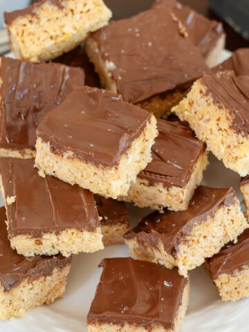 Chocolate peanut butter rice crispy treats stacked on a plate.